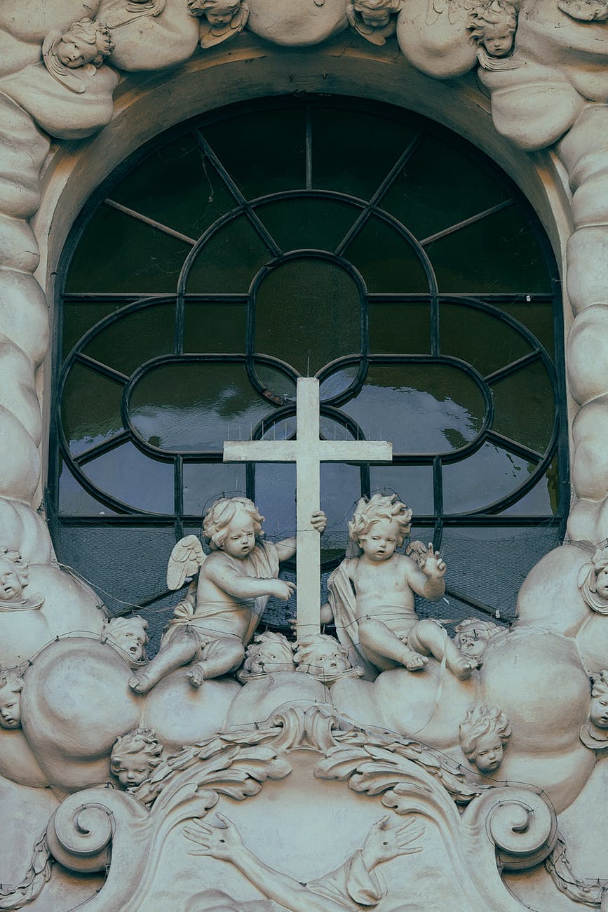 sculptures of angels near cathedral window