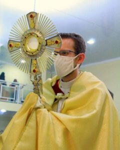 A priest carrying the monstrance using a humeral veil 